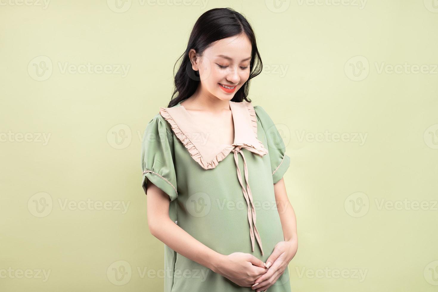 donna asiatica incinta che si sente felice e non vede l'ora di partorire foto
