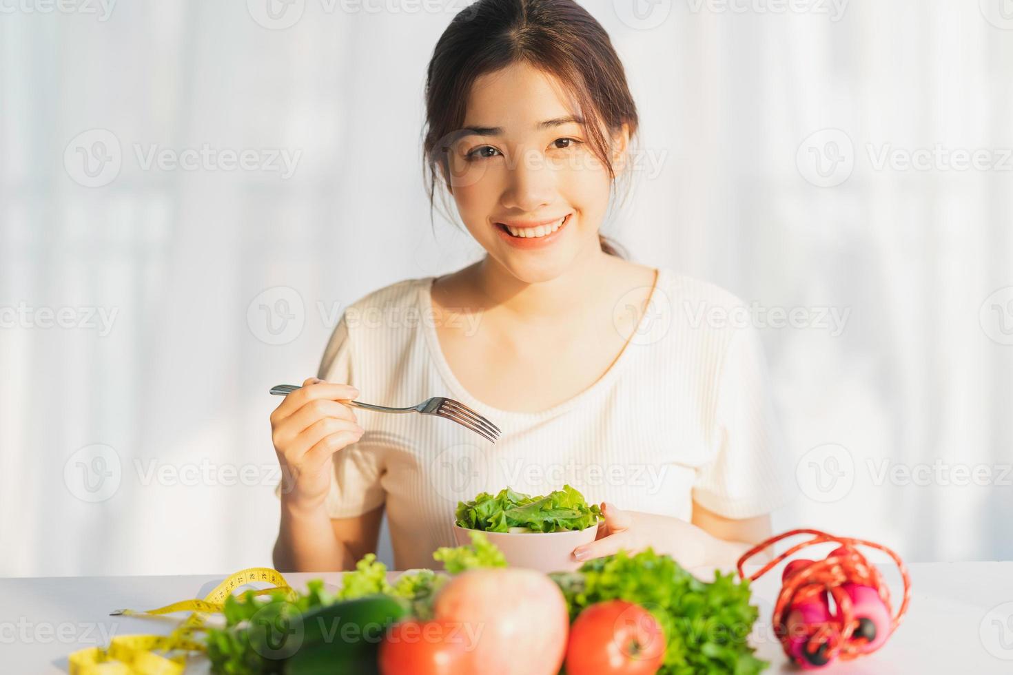 la giovane donna sta mangiando le verdure verdi per la perdita di peso foto