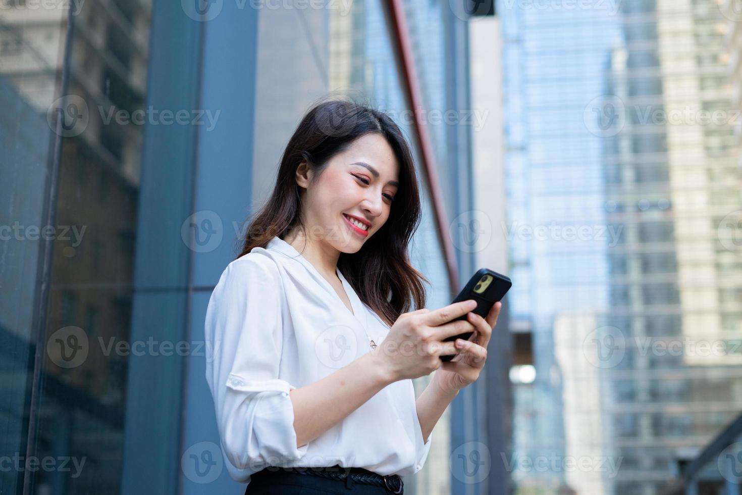 giovane donna asiatica che utilizza lo smartphone per inviare un messaggio ai suoi amici foto