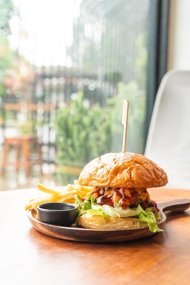 hamburger di manzo con formaggio e salsa su piatto di legno foto