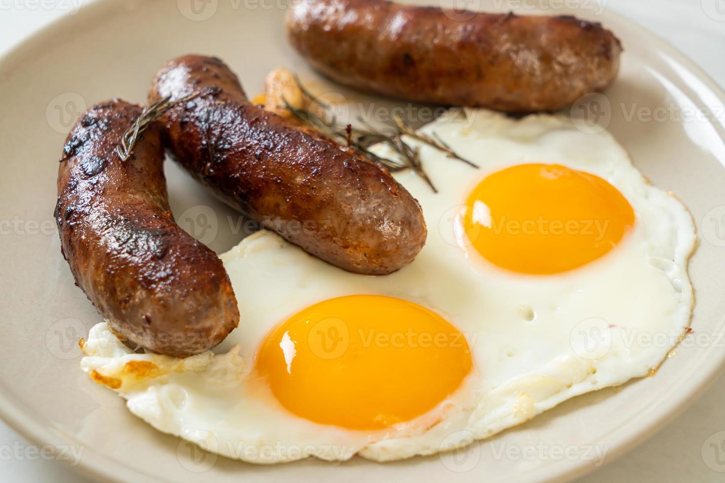 doppio uovo fritto fatto in casa con salsiccia di maiale fritta - per colazione foto