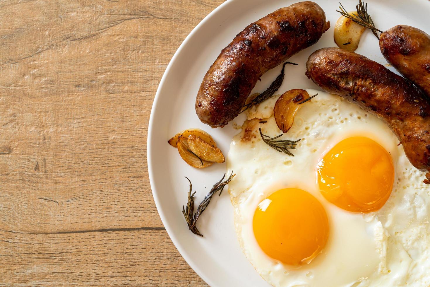 doppio uovo fritto fatto in casa con salsiccia di maiale fritta - per colazione foto