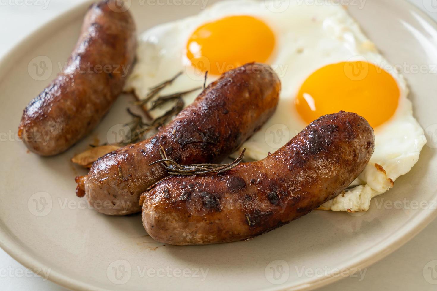 doppio uovo fritto fatto in casa con salsiccia di maiale fritta - per colazione foto