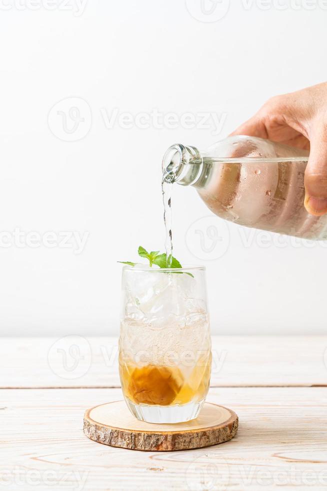 succo di prugna ghiacciato con soda e menta piperita sul tavolo di legno - bevanda rinfrescante foto