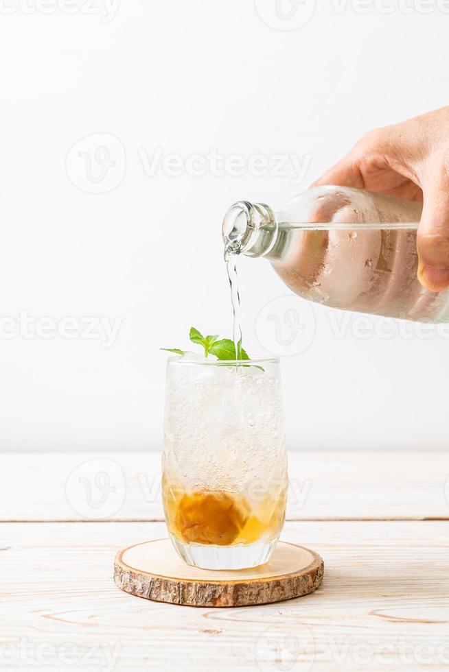 succo di prugna ghiacciato con soda e menta piperita sul tavolo di legno - bevanda rinfrescante foto