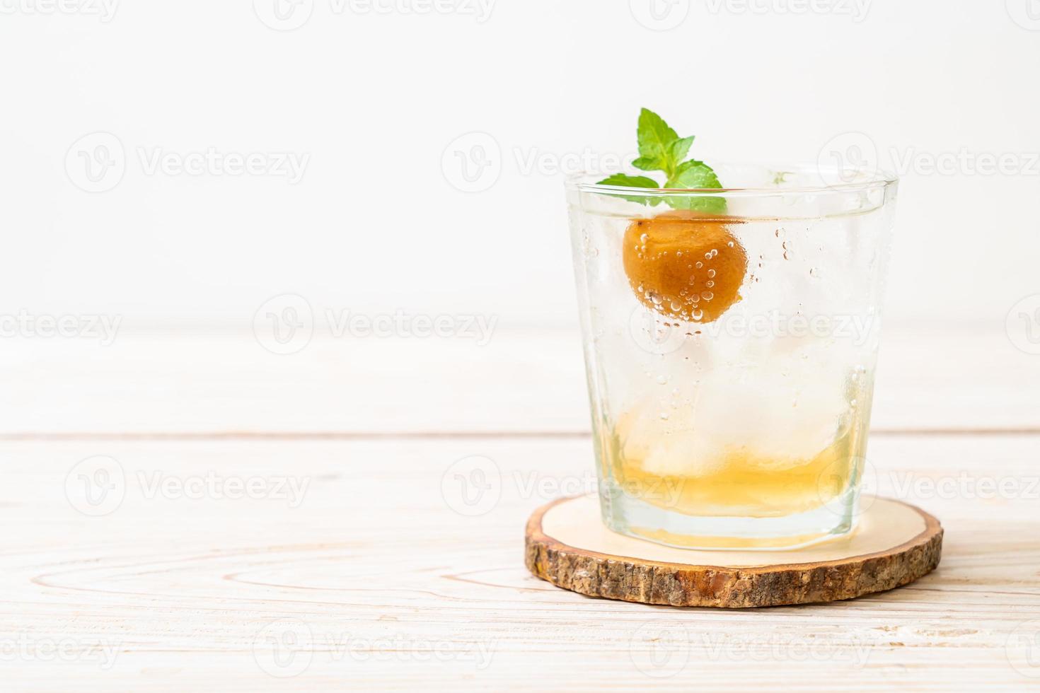 succo di prugna ghiacciato con soda e menta piperita sul tavolo di legno - bevanda rinfrescante foto