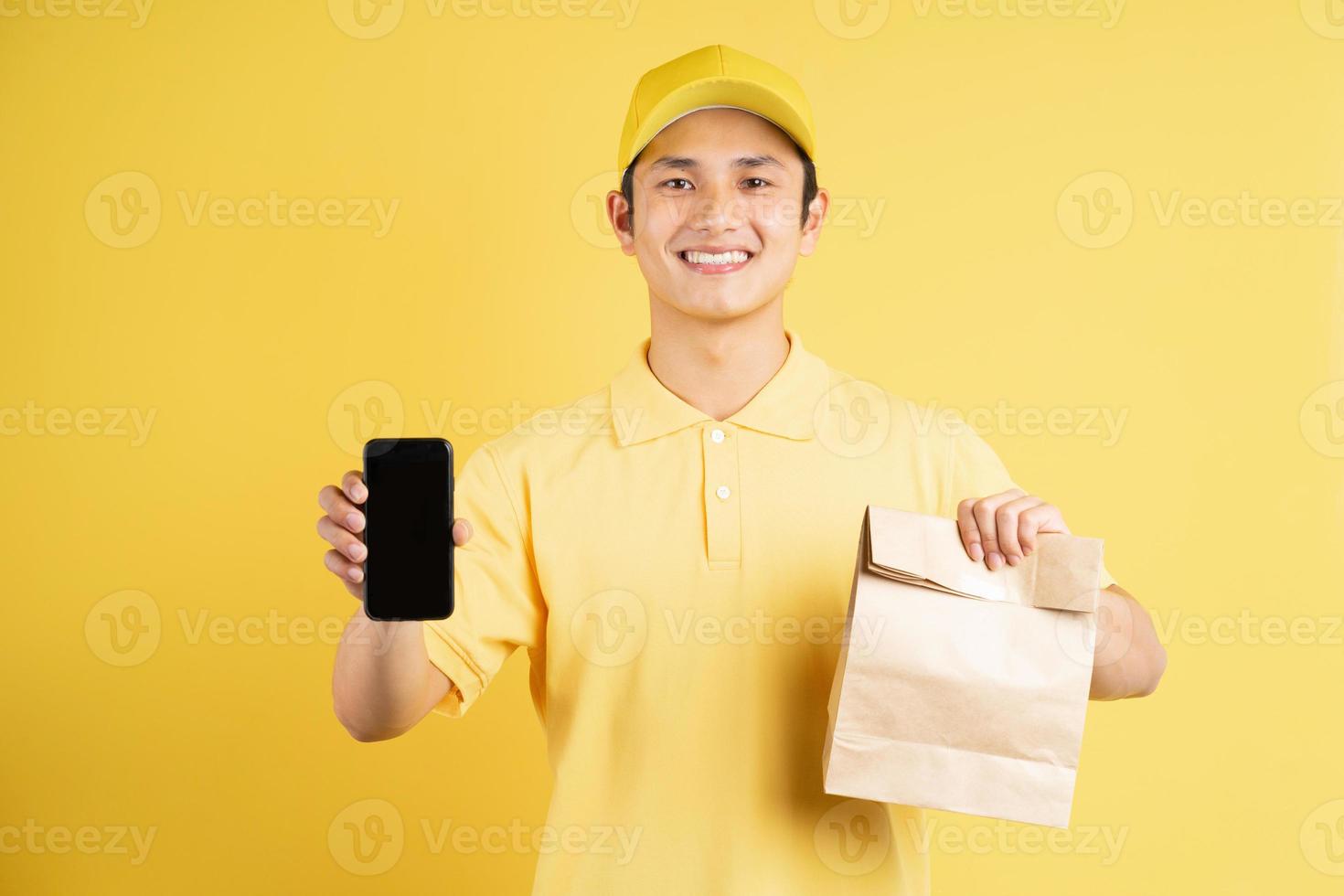 ritratto di fattorino maschio che tiene borsa della spesa e telefono foto