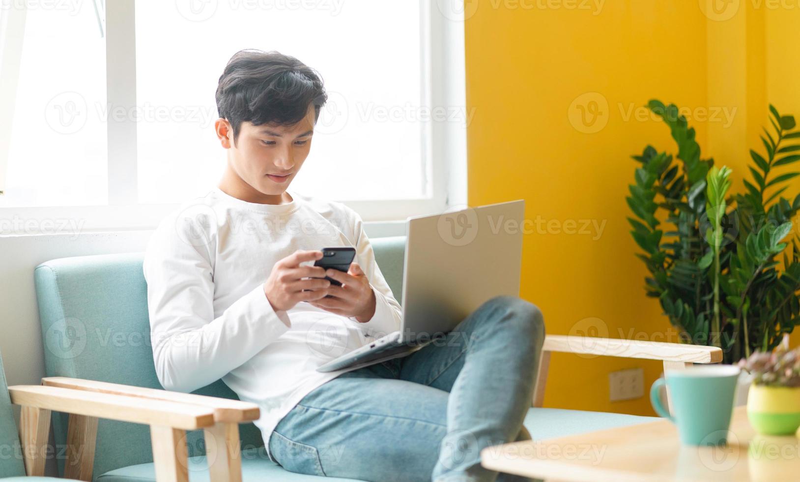 giovane uomo asiatico seduto che lavora a casa? foto