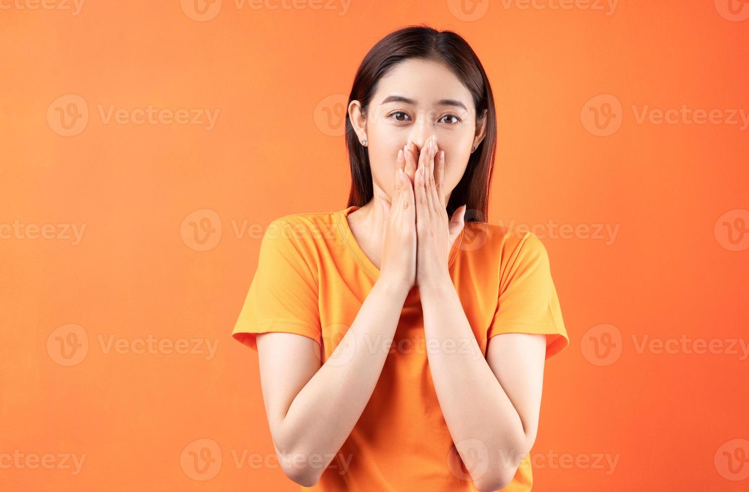 la donna asiatica si coprì la bocca perché era troppo sorpresa foto