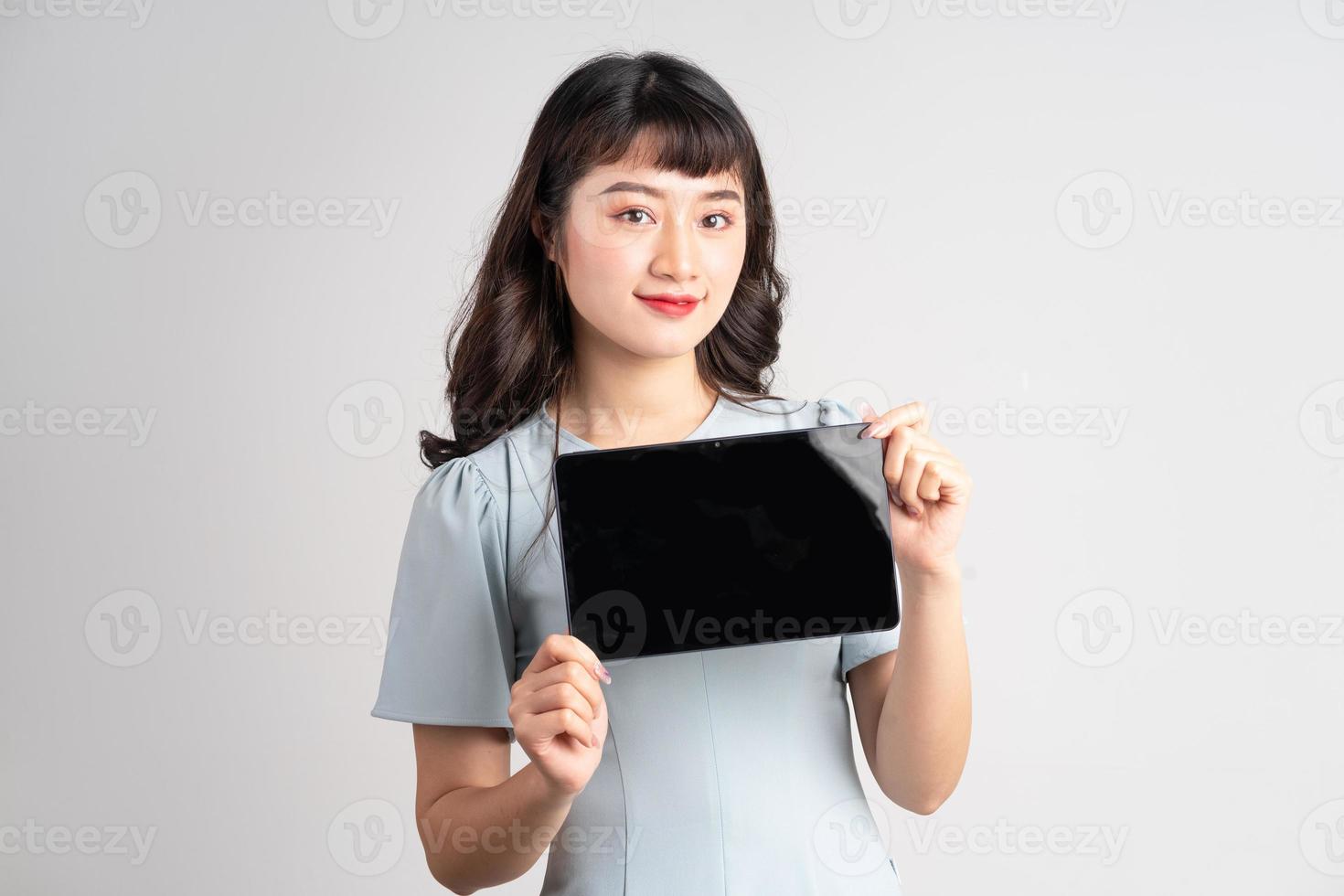 giovane donna asiatica che tiene compressa su sfondo bianco foto
