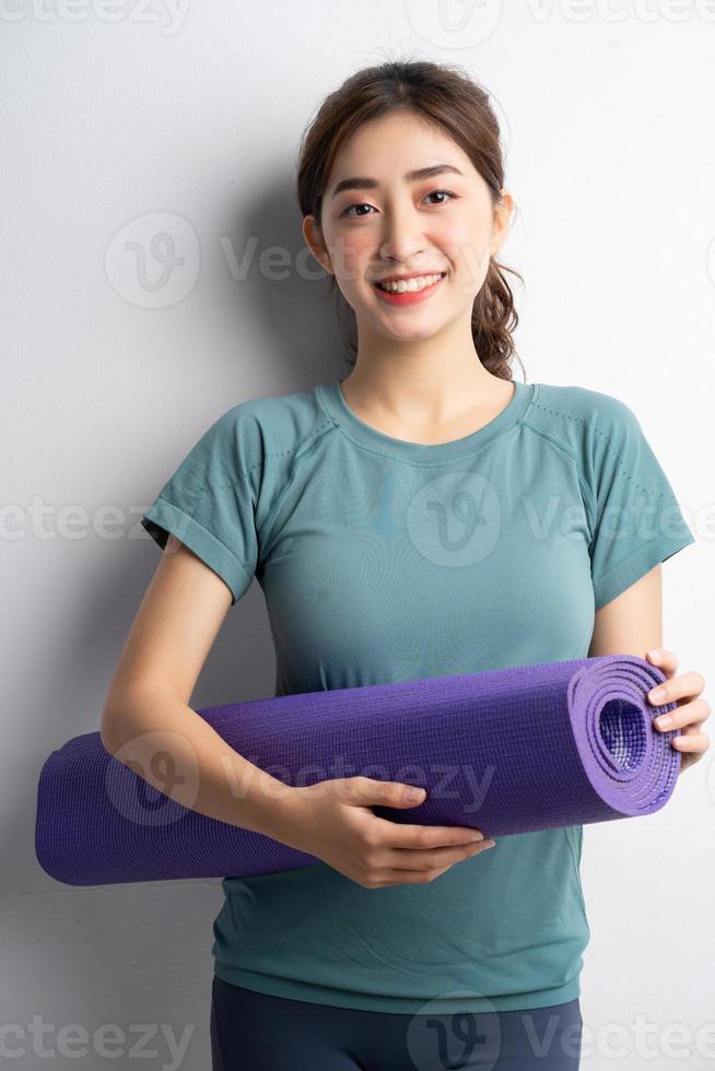 giovane donna asiatica che fa esercizio su sfondo bianco foto