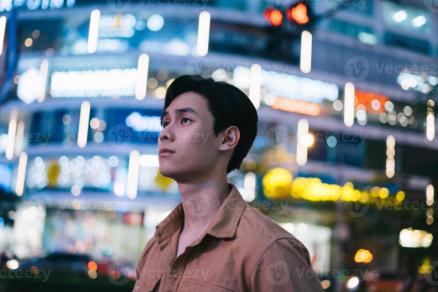 l'uomo asiatico cammina per strada di notte sentendosi perso foto