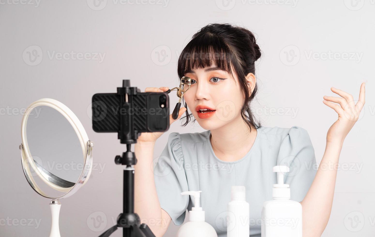 giovane donna asiatica in live streaming per insegnare il trucco online foto