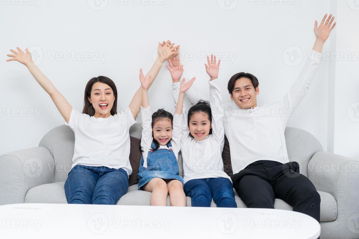 giovane famiglia asiatica intrattenuta a casa nel tempo libero foto