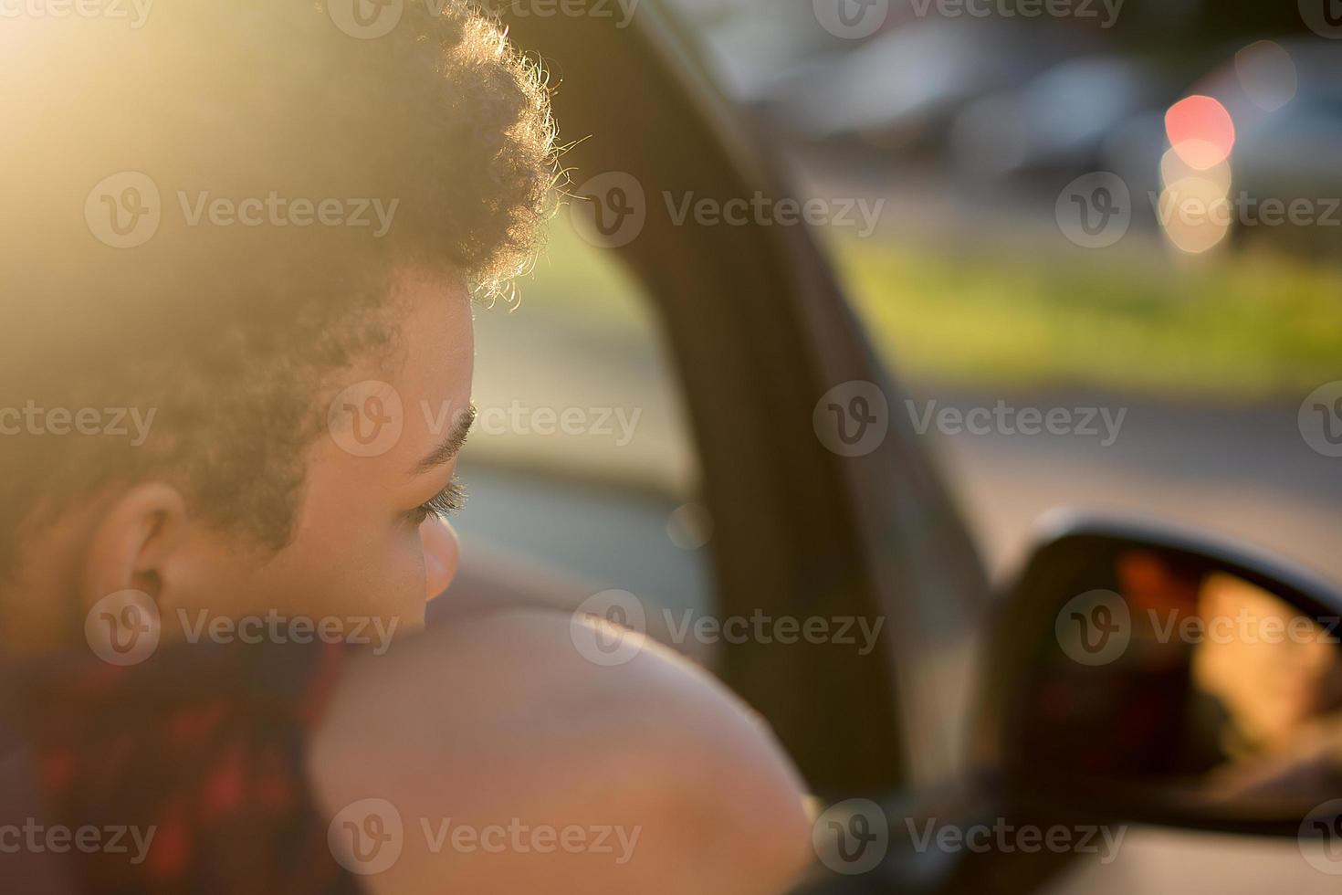 seria e bella donna afroamericana con i capelli corti in macchina, stile di vita foto