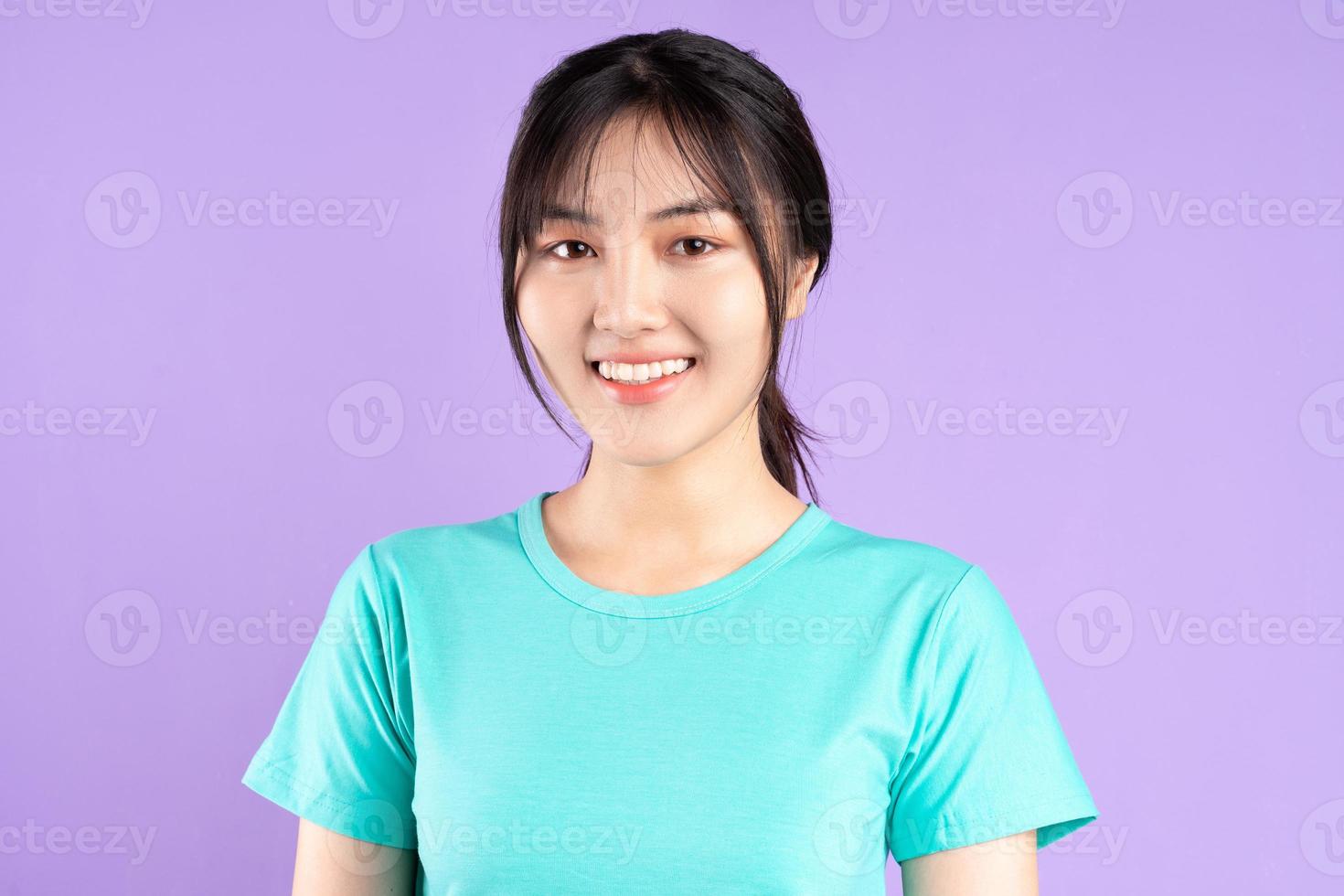giovane ragazza asiatica in camicia ciano su sfondo viola foto