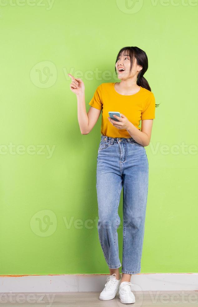 ritratto completo del corpo di giovane ragazza asiatica su sfondo verde green foto