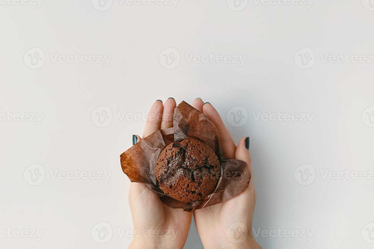 muffin al cioccolato nelle mani della donna. foto