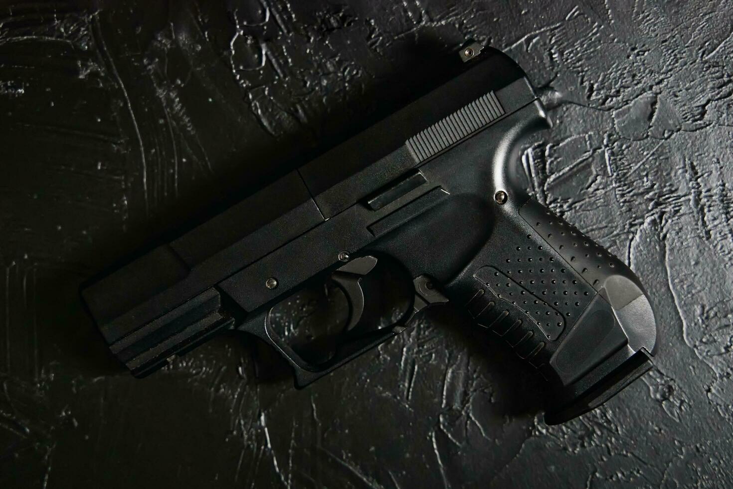 pistola sul tavolo trama nera. foto