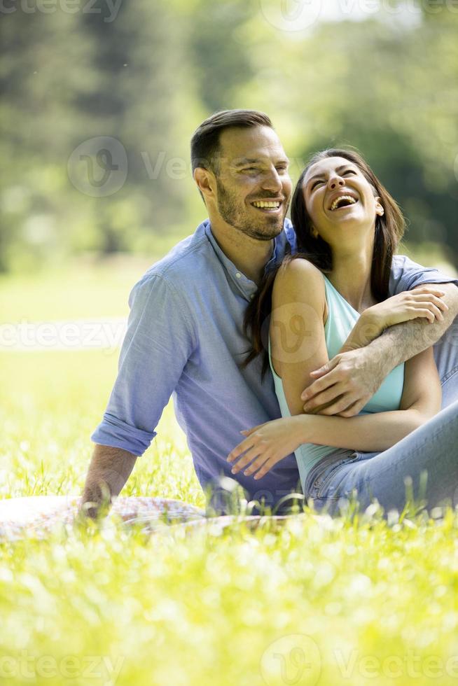 affettuoso giovane coppia seduta sull'erba verde foto