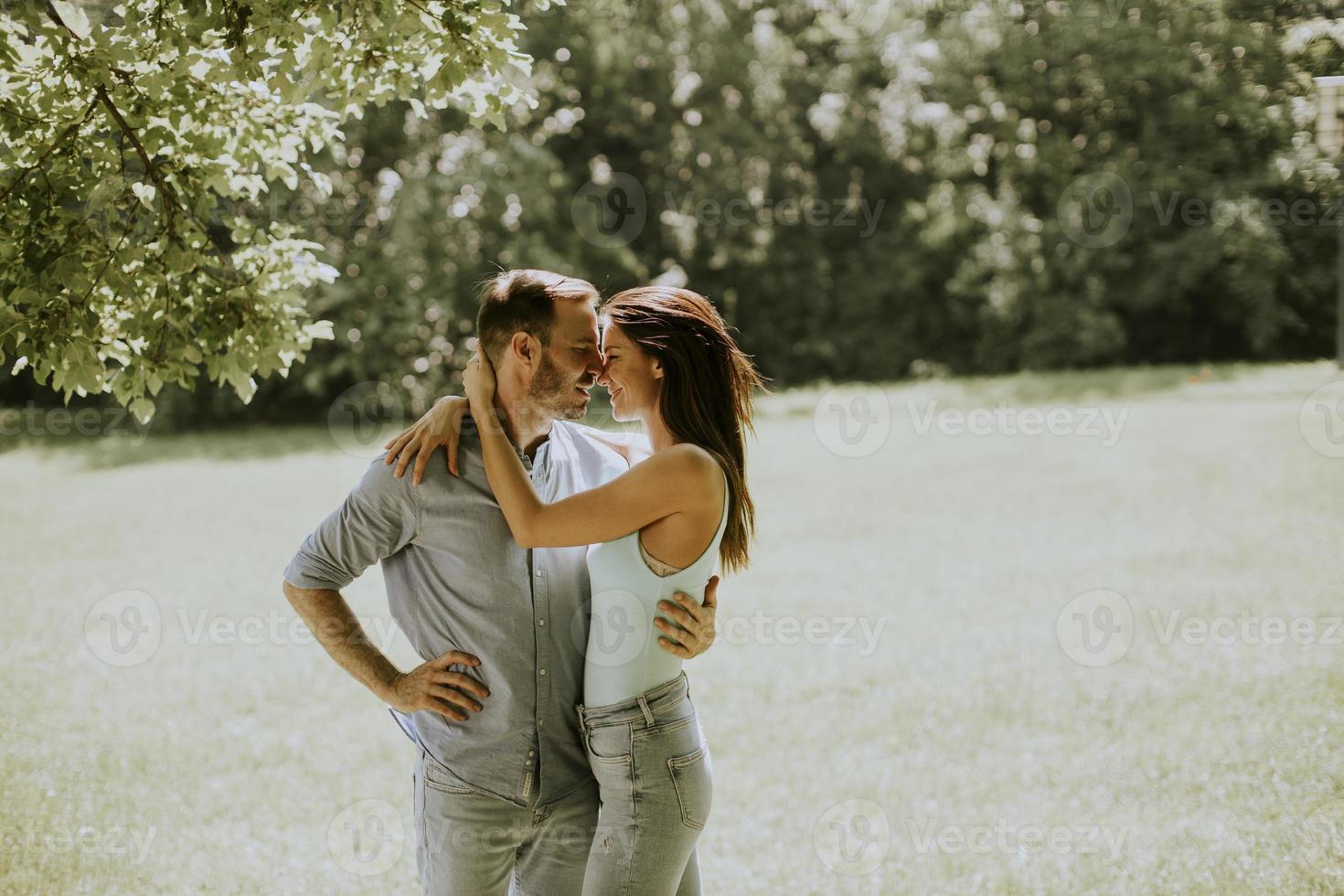 giovane coppia affettuosa che si diverte sull'erba verde foto