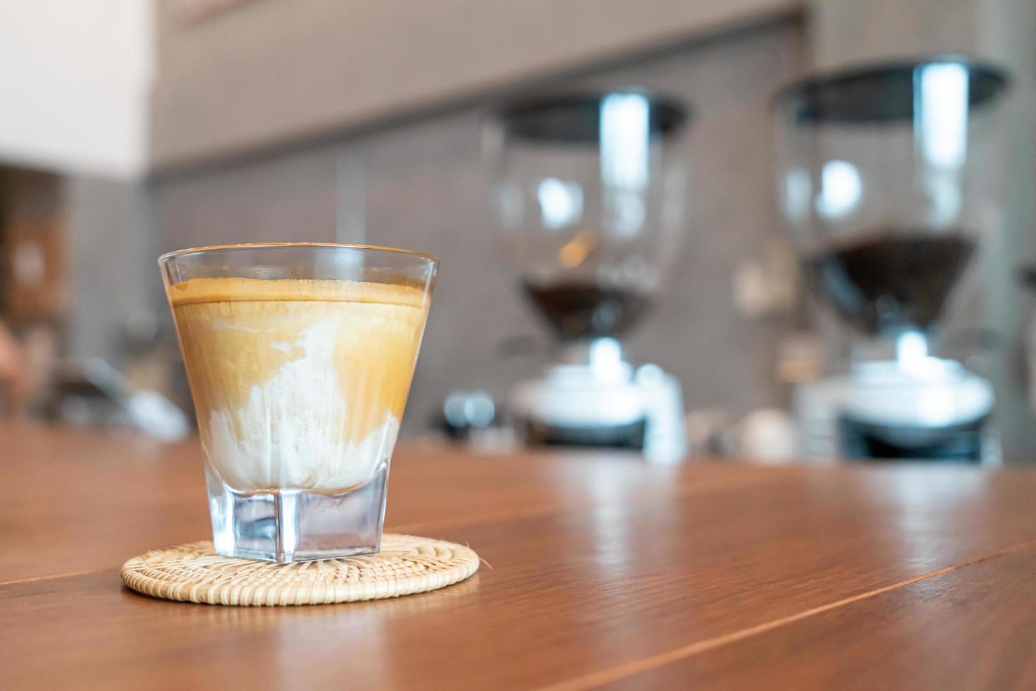 bicchiere di caffè sporco, o latte freddo condito con un caffè espresso caldo, in una caffetteria foto