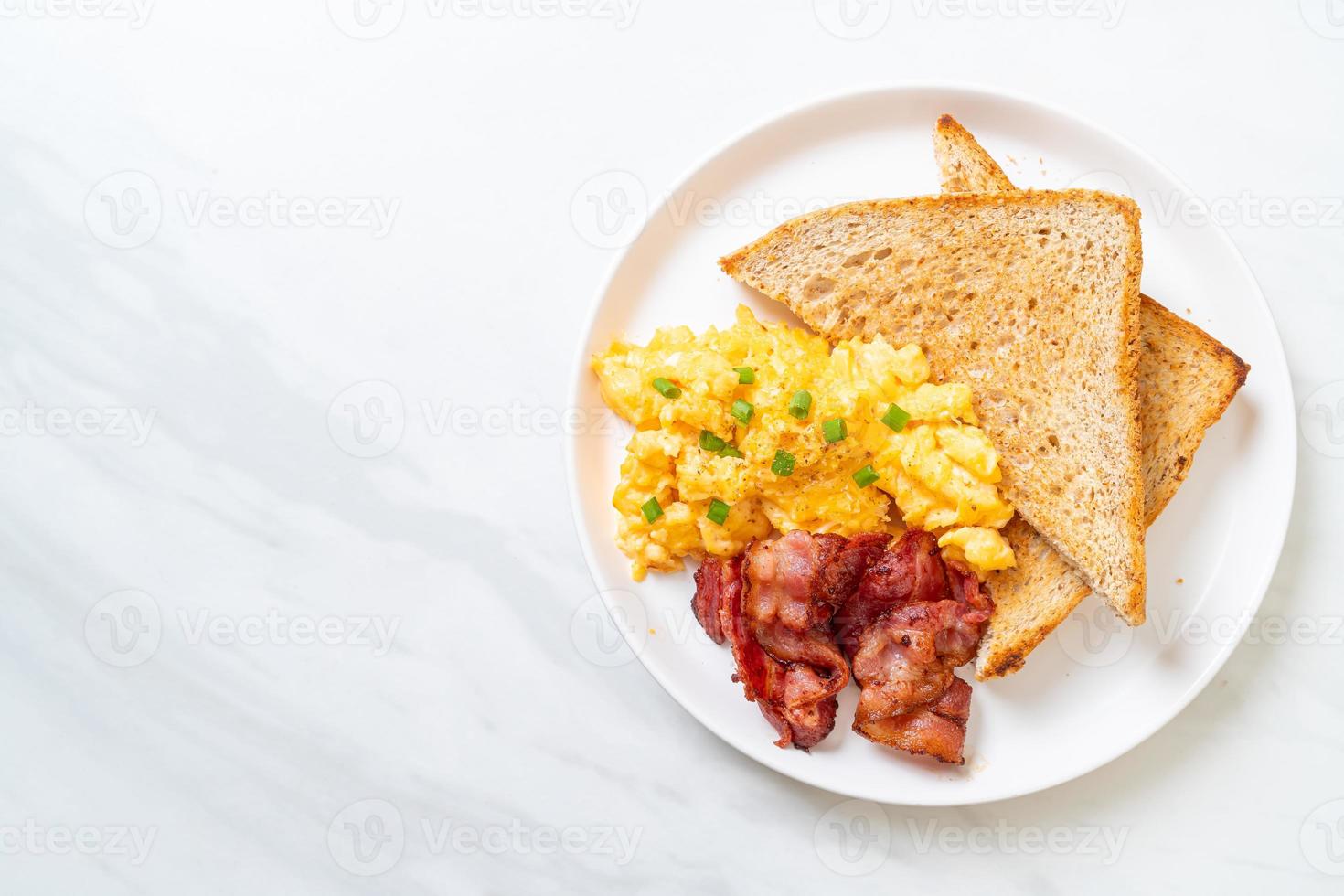 uova strapazzate con pane tostato e pancetta a colazione foto