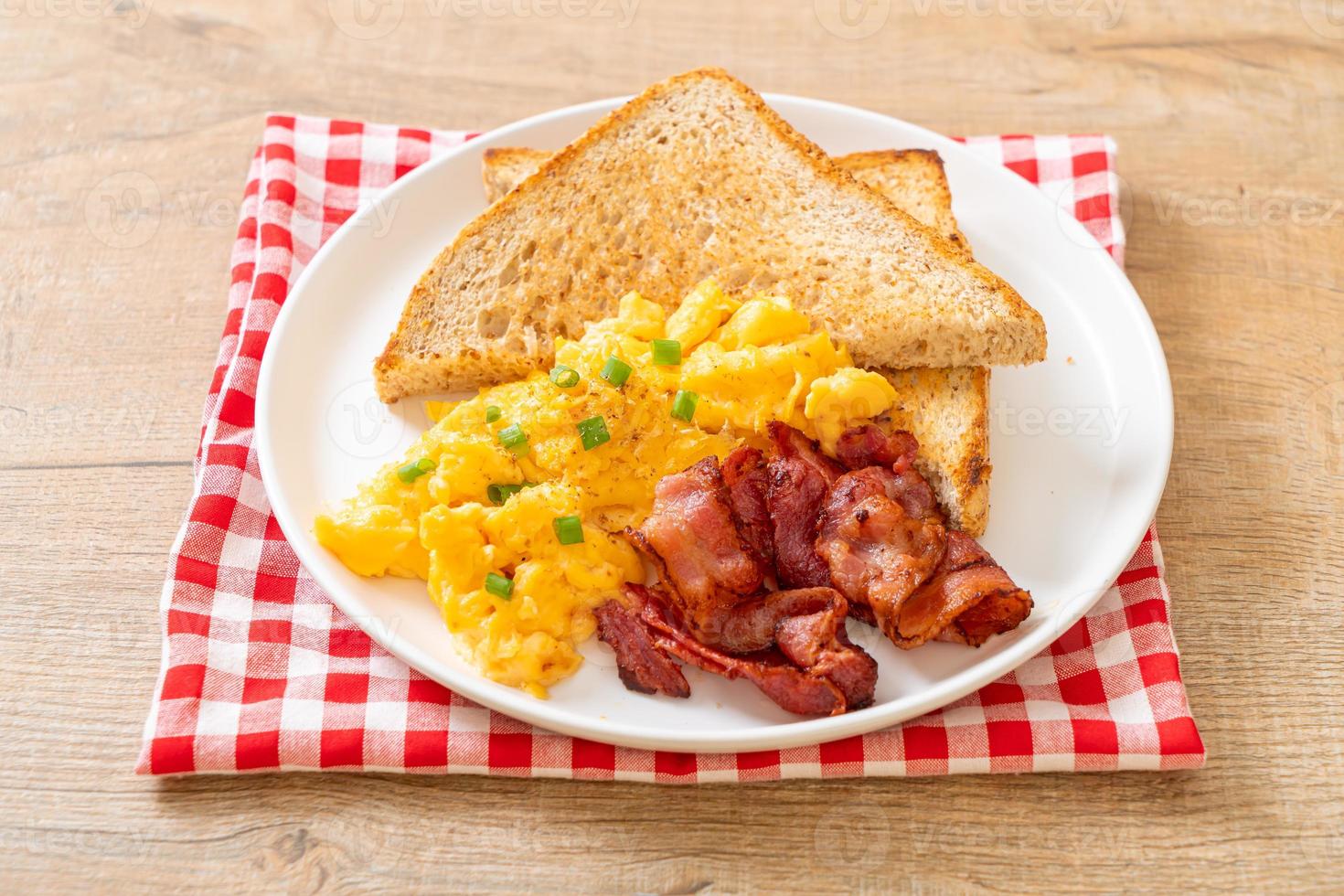 uova strapazzate con pane tostato e pancetta a colazione foto