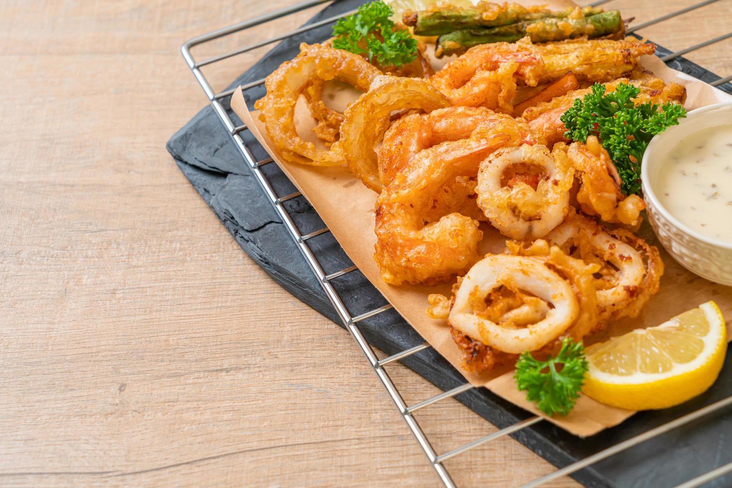 frutti di mare fritti di gamberi e calamari con verdure miste - stile alimentare malsano foto
