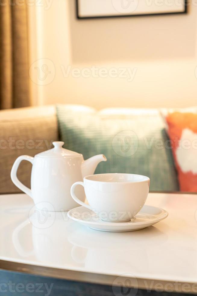 tazza da tè bianca con teiera sul tavolo foto