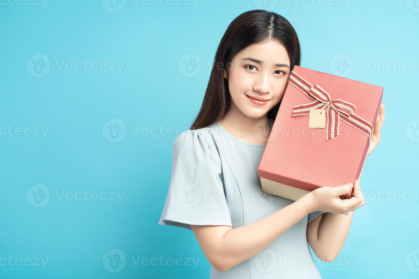 donna asiatica che tiene scatola regalo foto