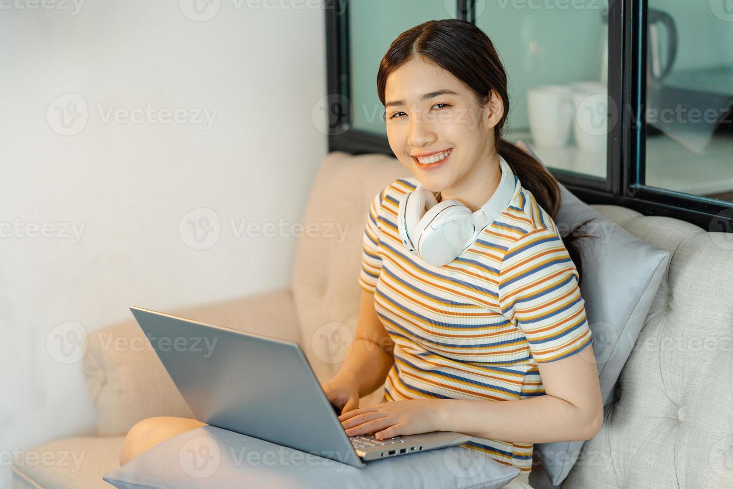 donna seduta sul divano che usa il computer foto