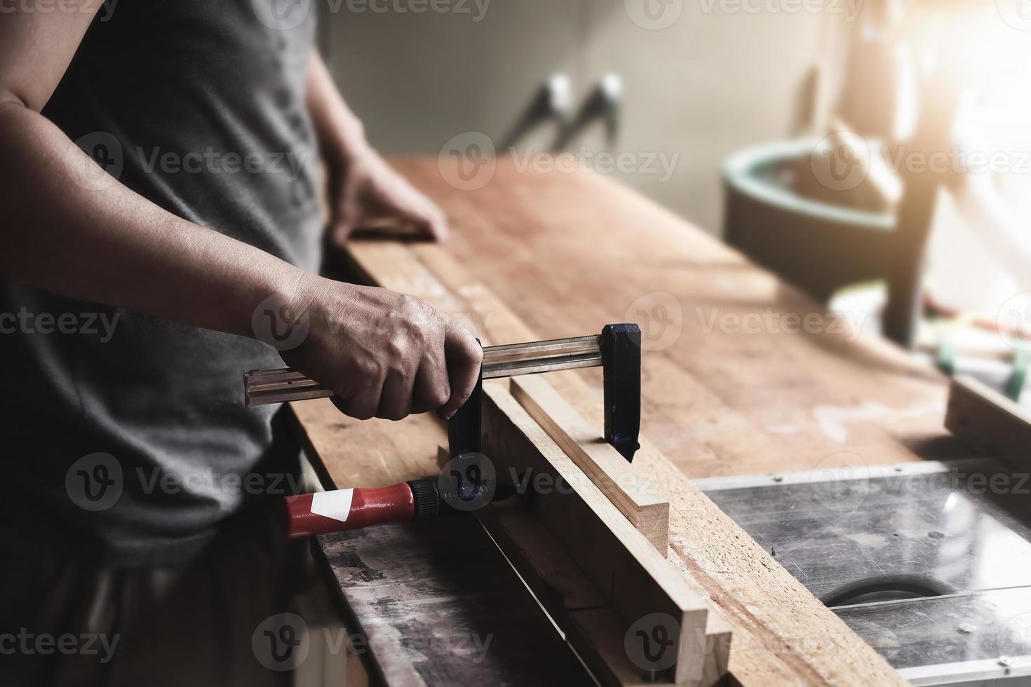 gli operatori della lavorazione del legno stanno decorando pezzi di legno per assemblare e costruire tavoli in legno per il cliente foto