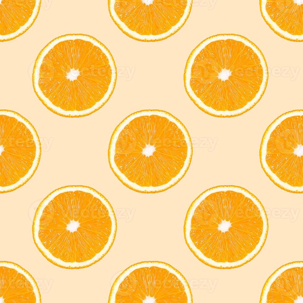 modello senza cuciture realizzato da fette di frutta arancione su fondo beige. foto