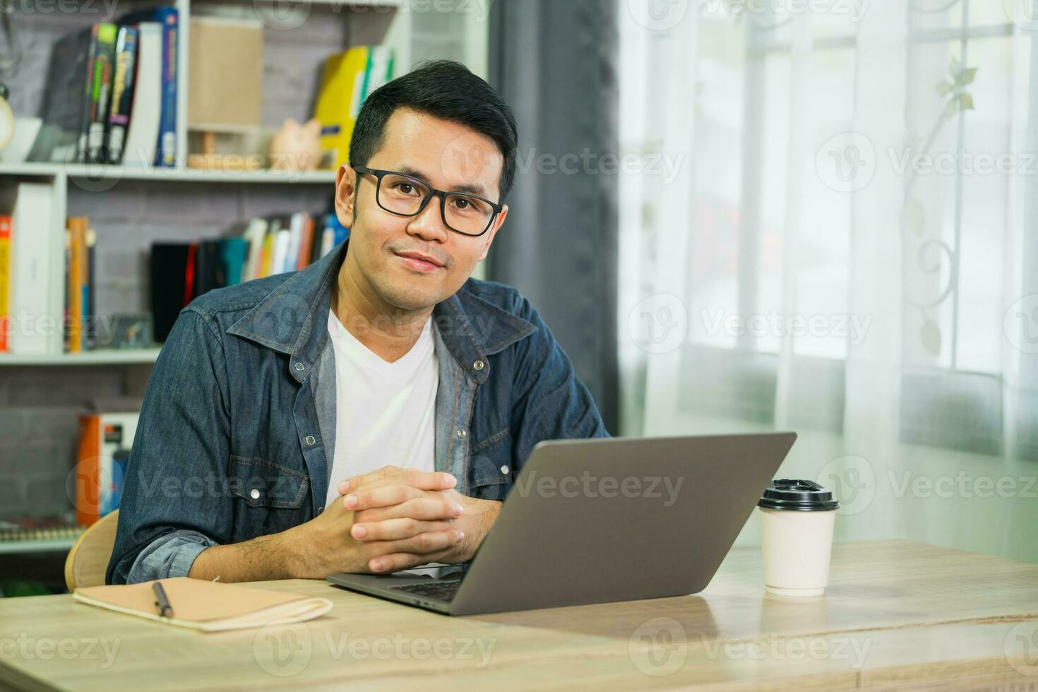 inteligente asiatico uomo sorridente indossare bicchieri Lavorando con computer il computer portatile. concetto opera modulo casa, restare a casa. libero professionista vita stile, nuovo normale sociale distanziamento stile di vita. opera modulo dovunque concetto. foto