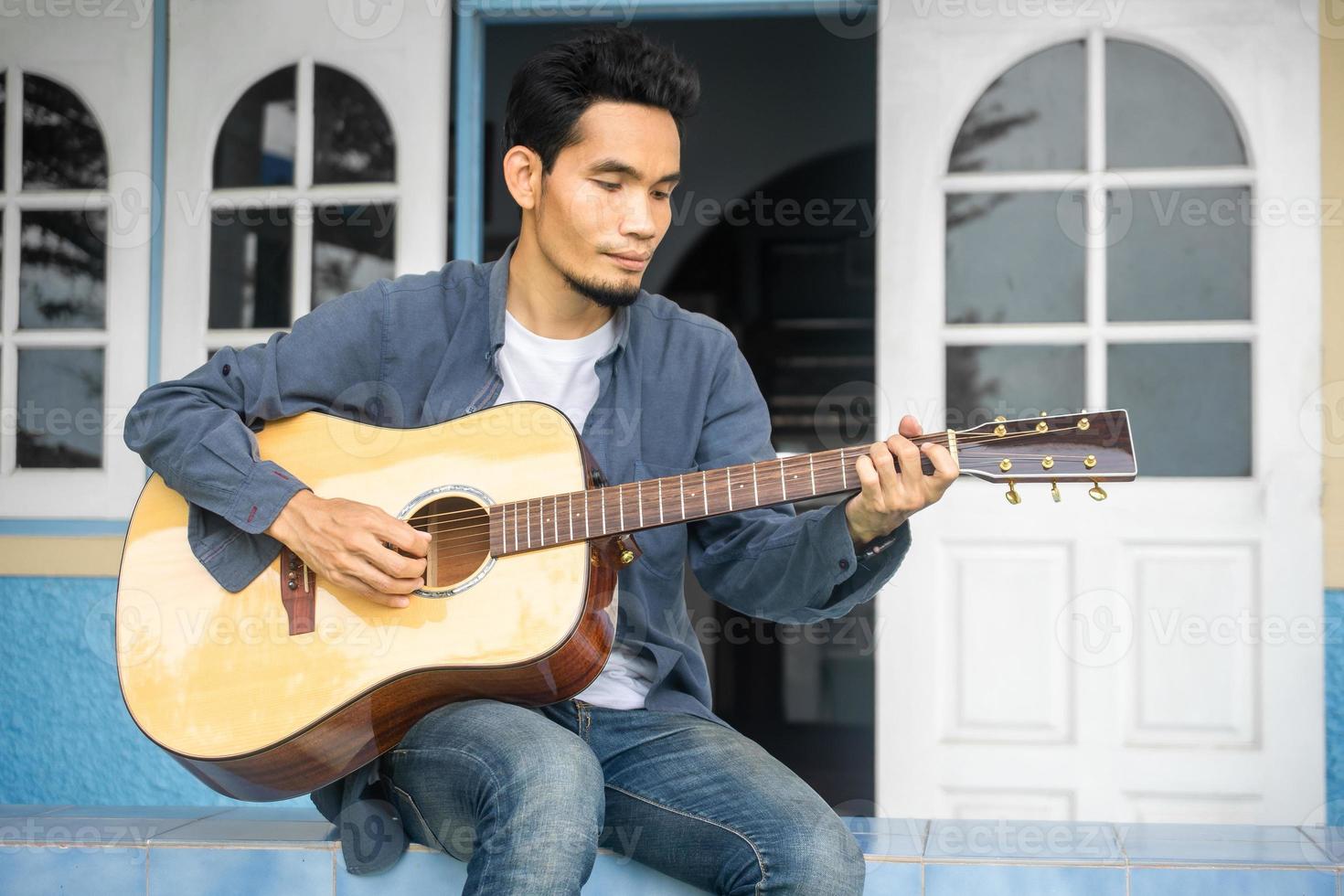 uomo che suona la chitarra felice tempo libero a casa foto