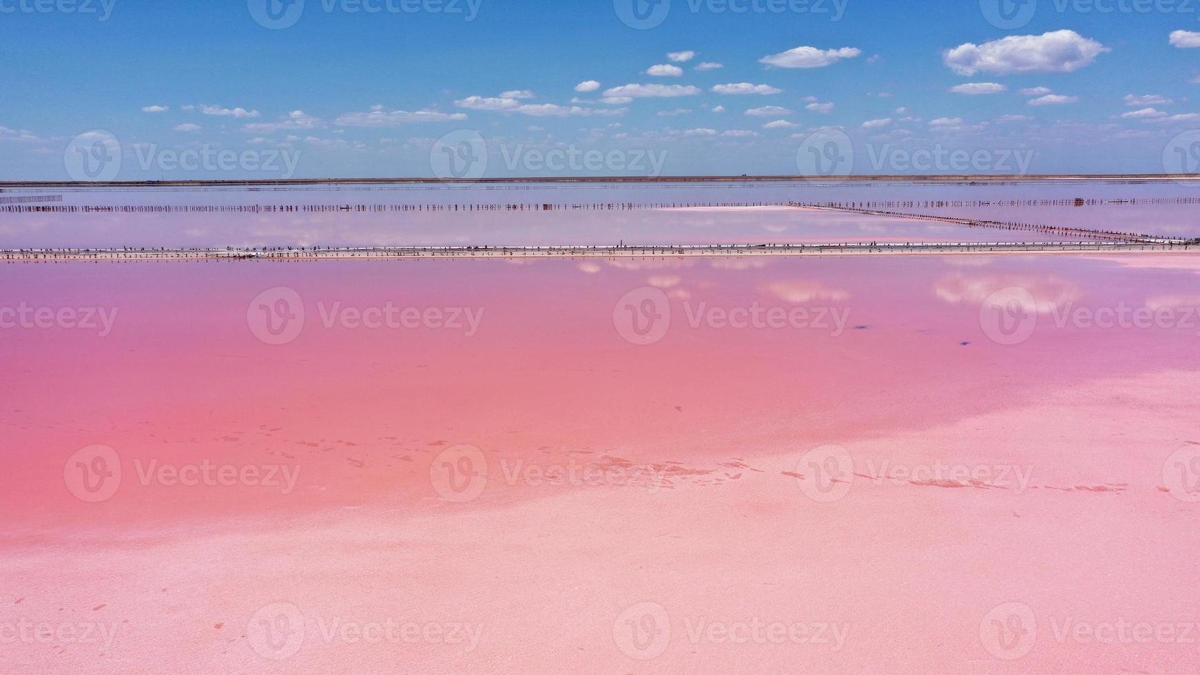 drone aereo foto dall'alto in basso di un lago rosa naturale e cielo blu kuyalnik a odessa, ucraina. il lago si colora naturalmente di rosa a causa dei sali e delle piccole artemia di crostacei presenti nell'acqua. questo miracolo è raro