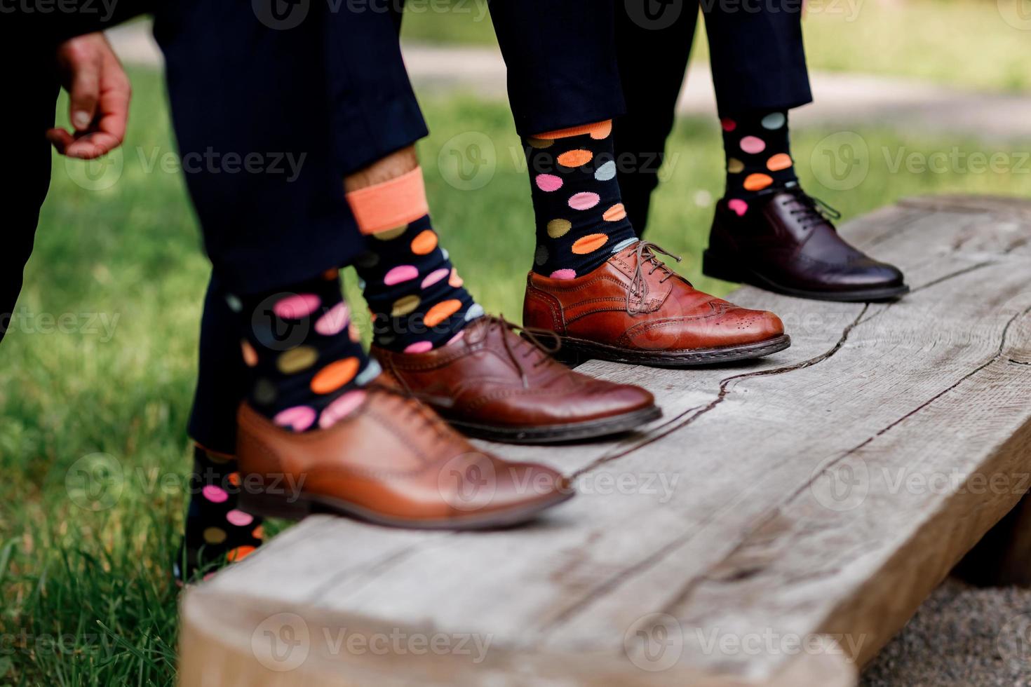 calzature moda uomo. ragazzi che indossano scarpe di pelle e calzini colorati su una panca di legno. messa a fuoco selettiva. foto