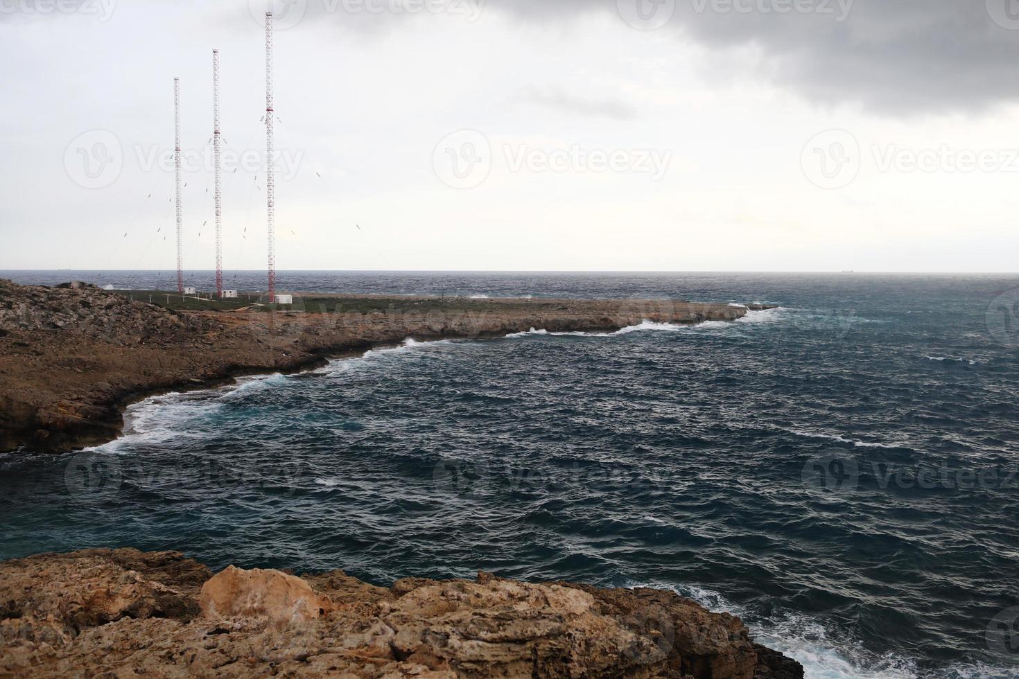 onde che colpiscono le scogliere rocciose in una spiaggia situata a Cipro, questo tempo potrebbe essere pericoloso per gli sport acquatici ma allo stesso tempo le onde e i loro spruzzi sono belli e selvaggi foto