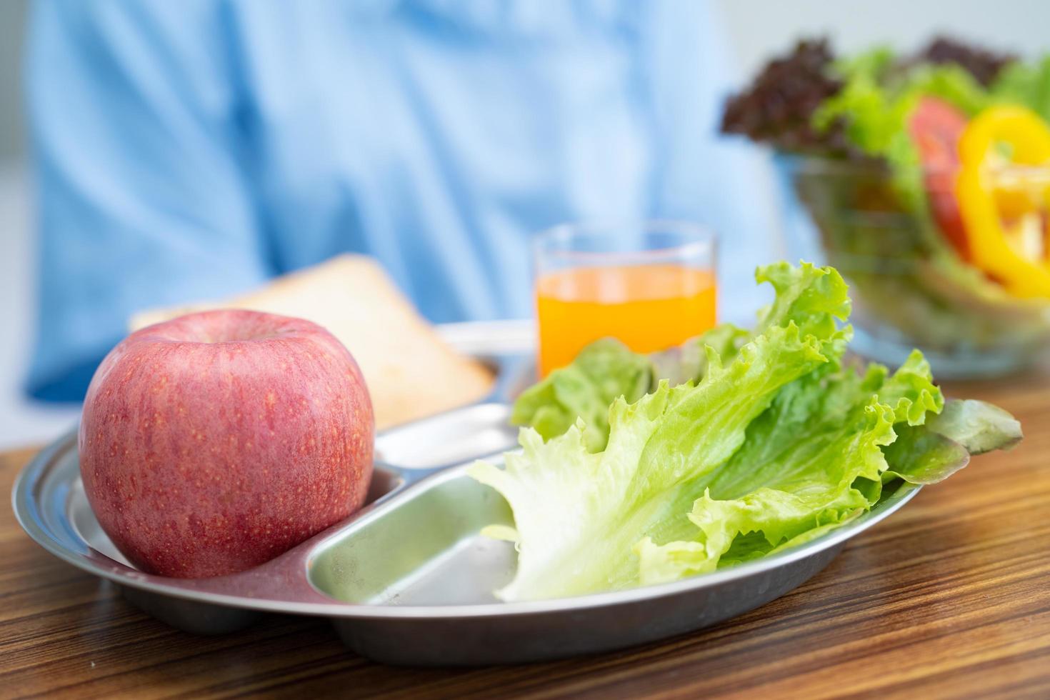 asiatico anziano o anziana signora anziana paziente che mangia colazione vegetale cibo sano con speranza e felice mentre è seduto e affamato sul letto in ospedale. foto