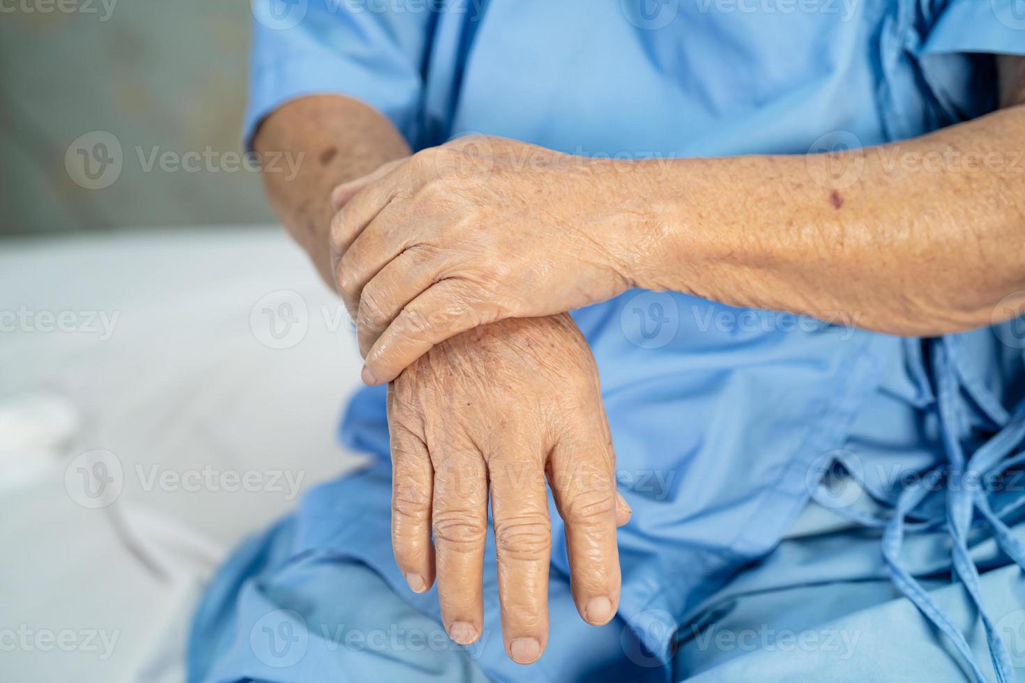 il paziente asiatico anziana o anziana della signora anziana sente dolore la mano sul letto nel reparto ospedaliero di cura, concetto medico sano e forte. foto
