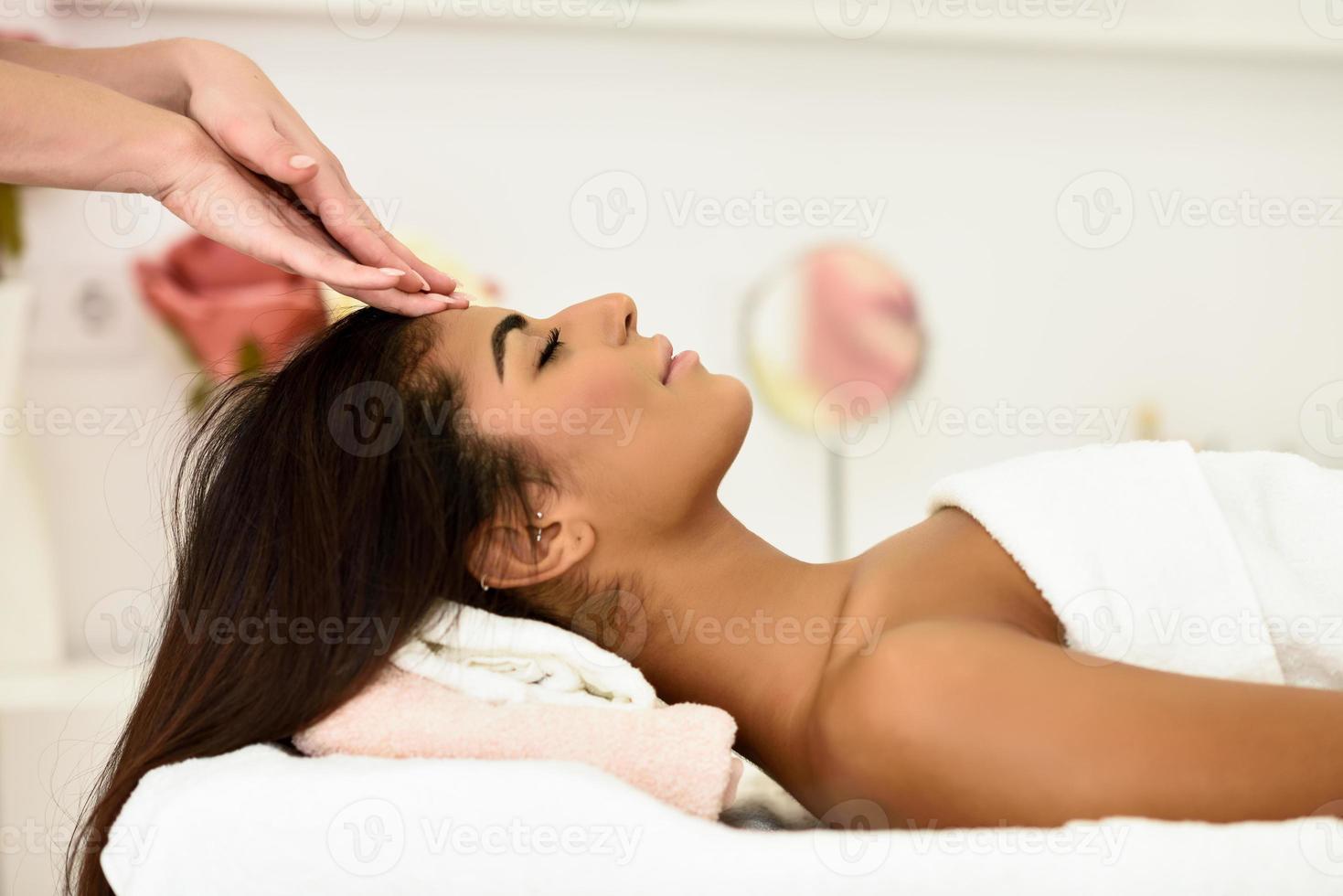 donna che riceve massaggio alla testa nel centro benessere spa. foto