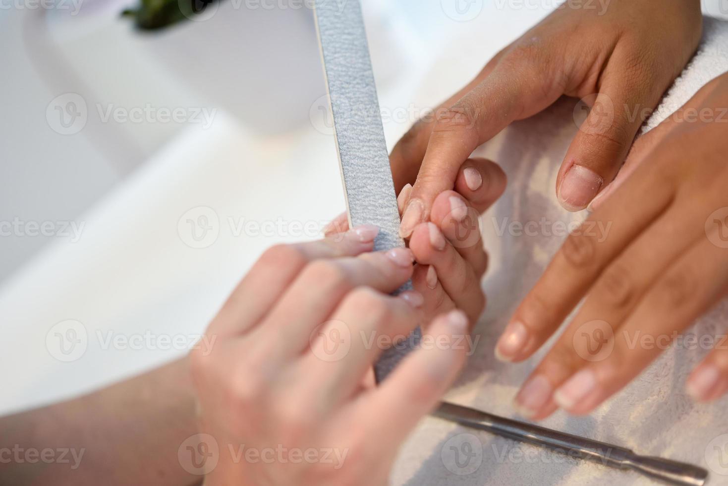 manicure cura delle unghie per il cliente seduto a un tavolo in ufficio. foto