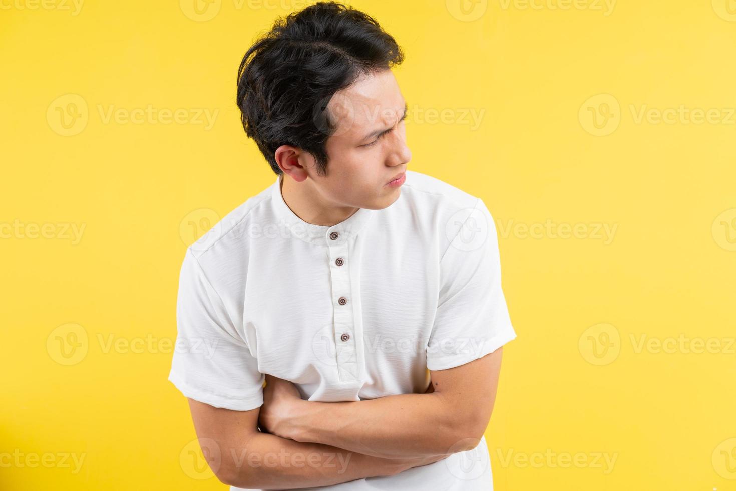 uomo asiatico che ha mal di stomaco su sfondo blu foto