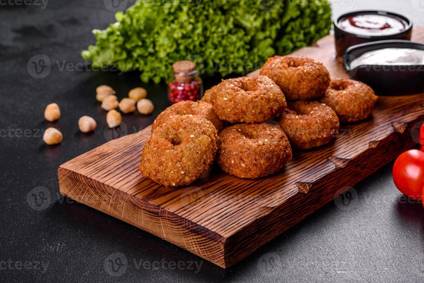 bellissimo delizioso falafel di ceci freschi con salse su uno sfondo di cemento foto