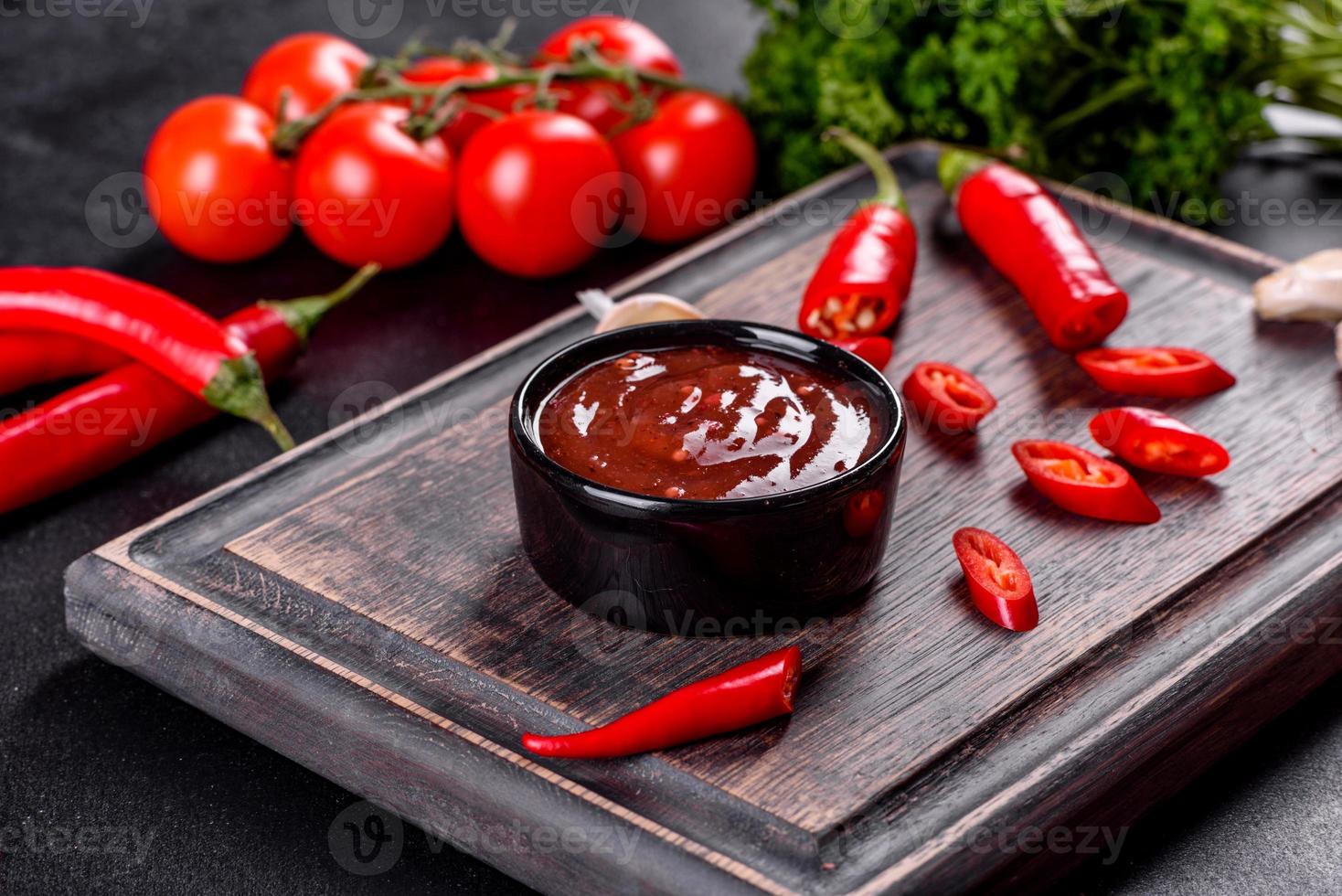 condimento piccante della cucina georgiana adjika in una ciotola con peperoncino e aglio foto