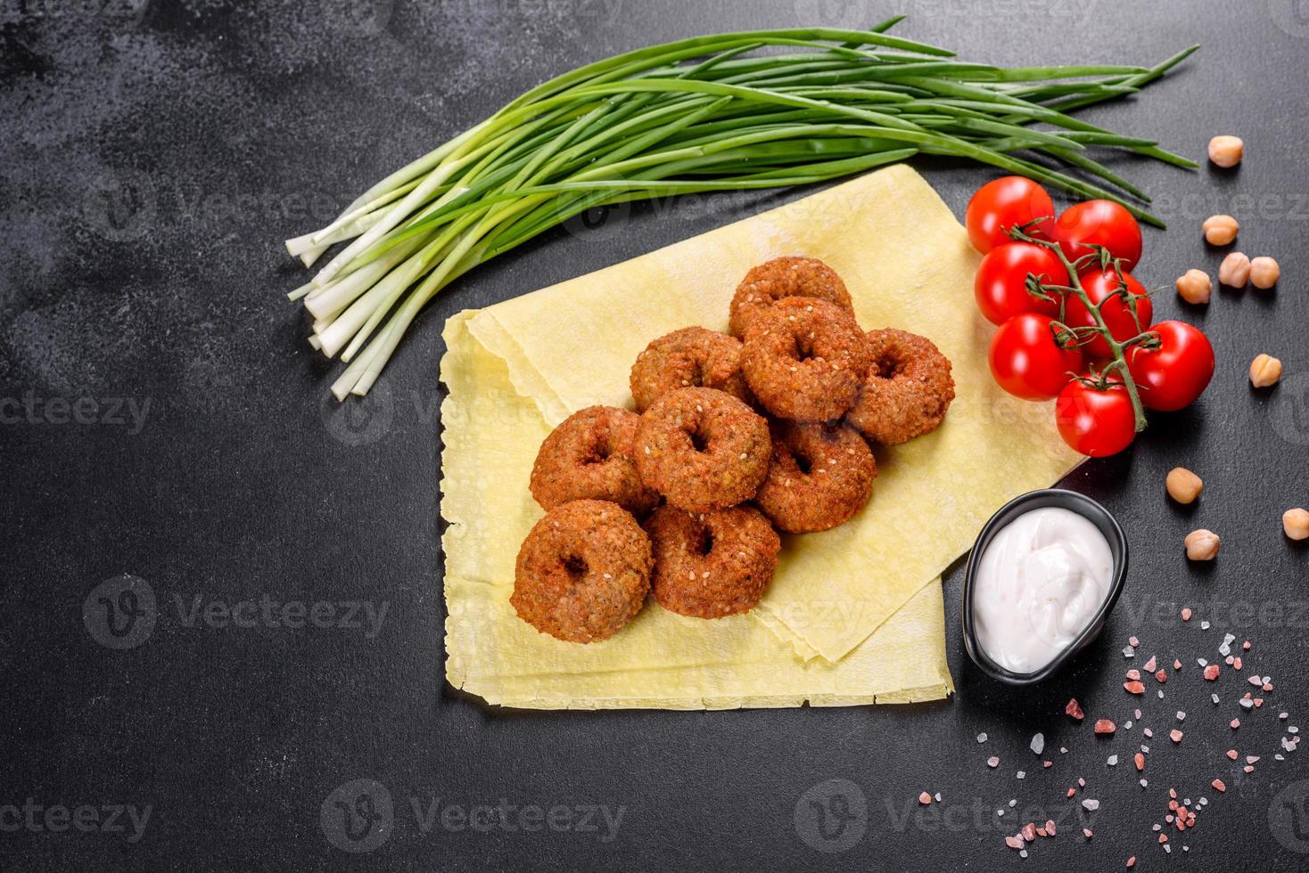 bellissimo delizioso falafel di ceci freschi con salse su uno sfondo di cemento foto