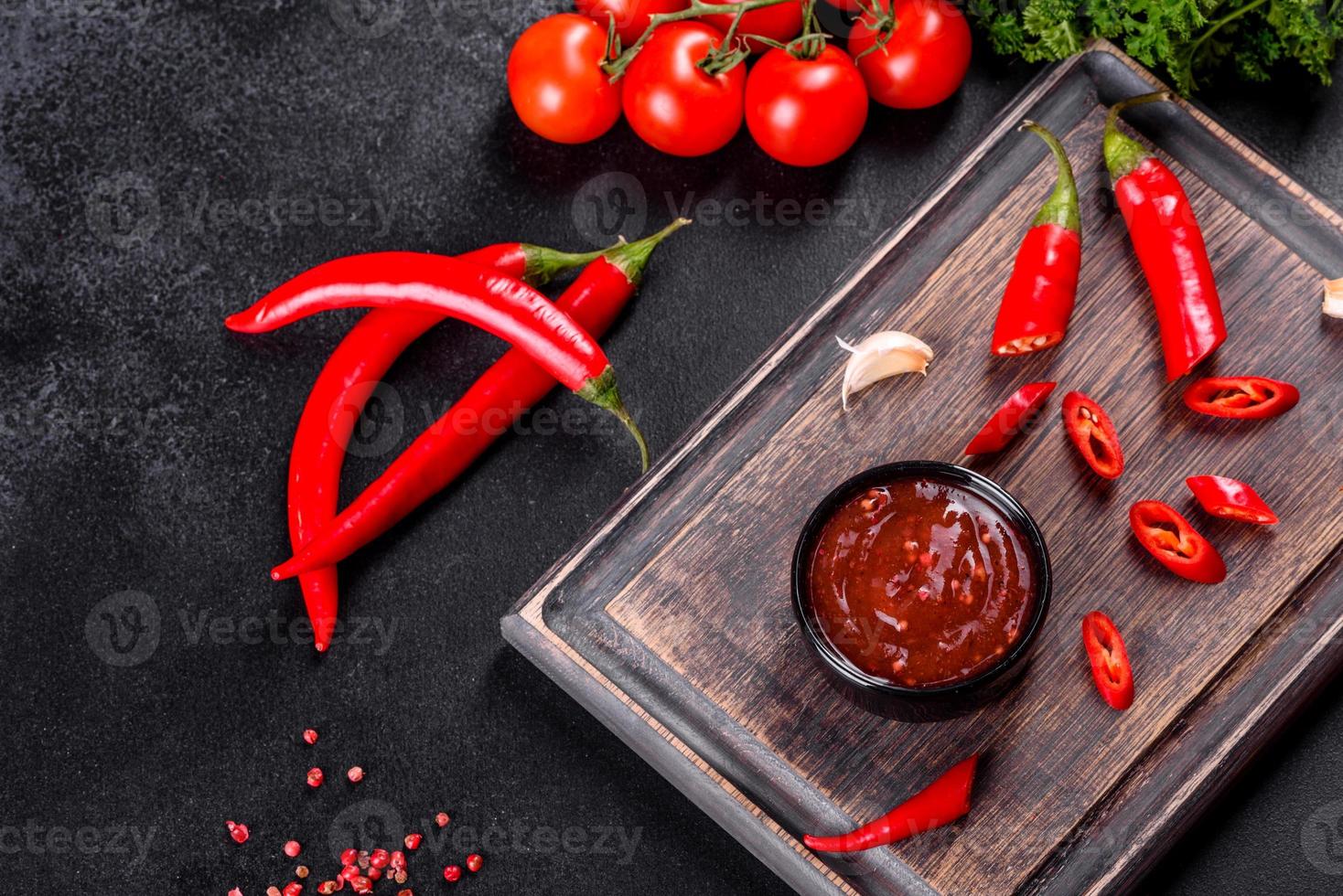 condimento piccante della cucina georgiana adjika in una ciotola con peperoncino e aglio foto