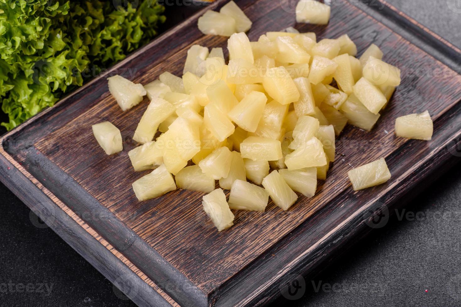 ananas in scatola con pezzi su un tagliere di legno foto