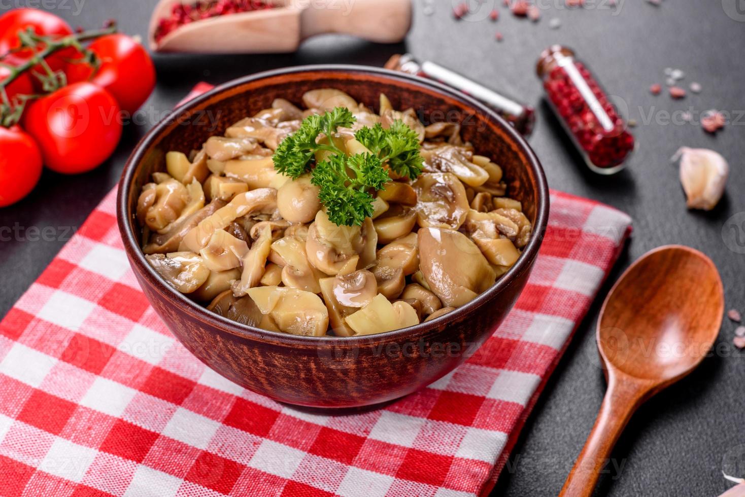 funghi in scatola piccanti deliziosi freschi con spezie ed erbe aromatiche in piatti di ceramica foto